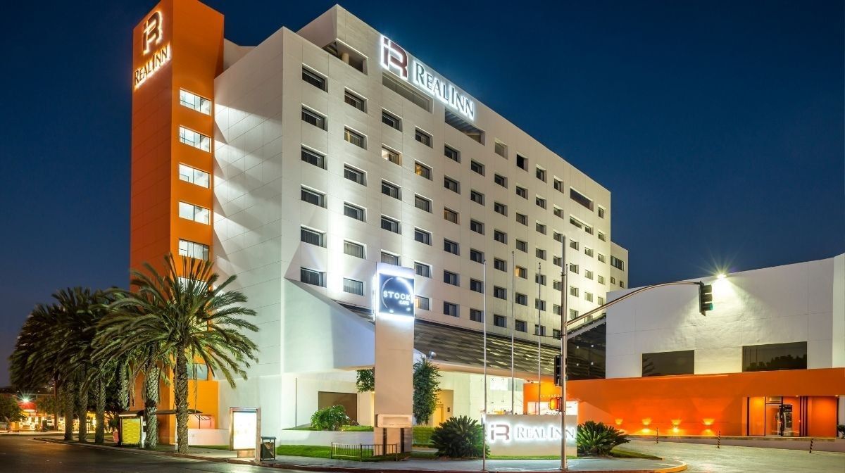 Camino Real Pedregal Mexico by tall palms under a dark night sky with orange accents