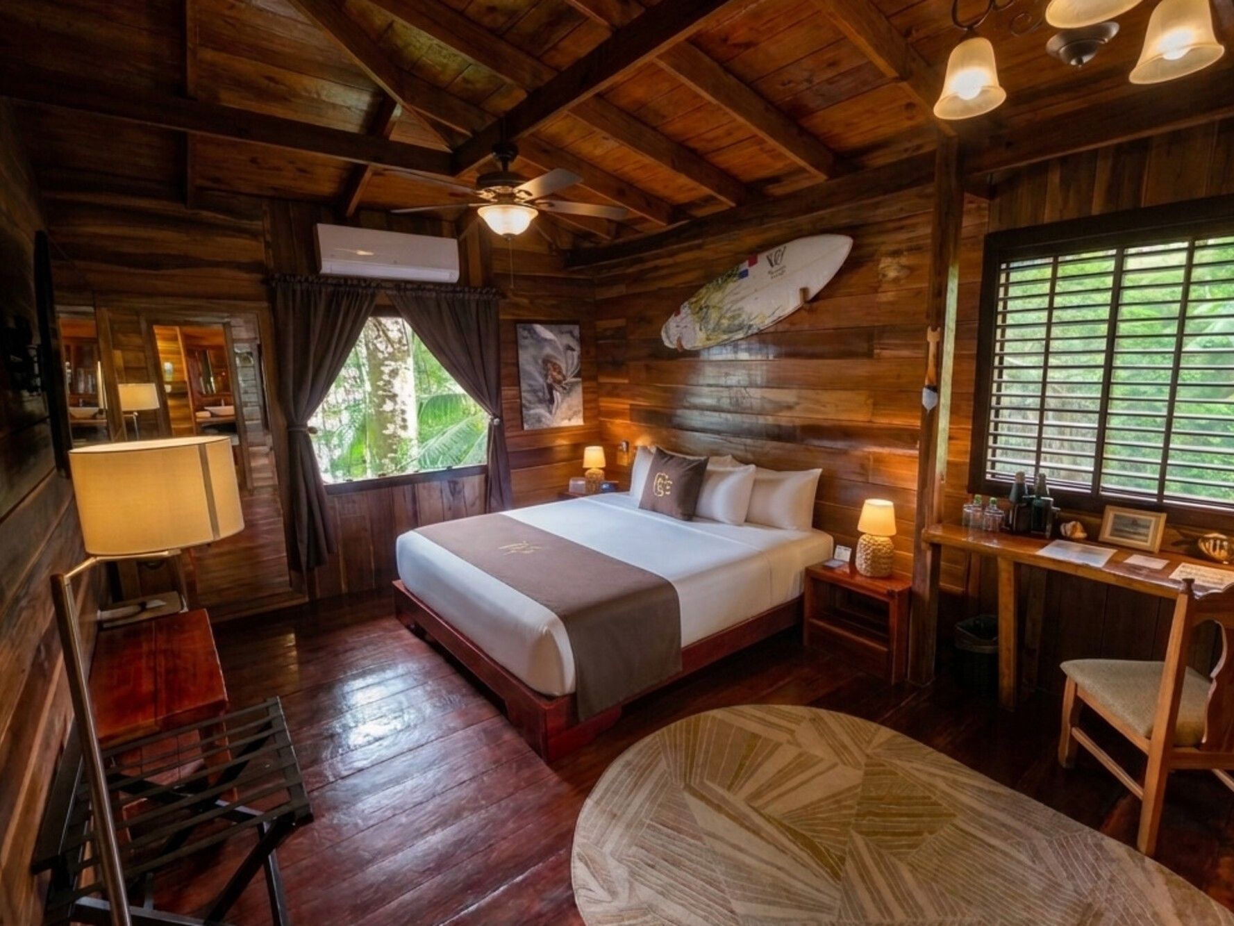 Habitación Alfa con cama, escritorio y detalles en madera Central Hotel Bocas Del Toro en Valle de Agua.