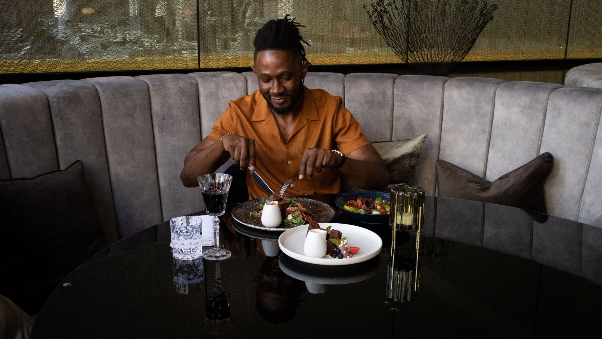 Man dining in a restaurant with a meal and drinks served on a table at Sofitel Brisbane Central