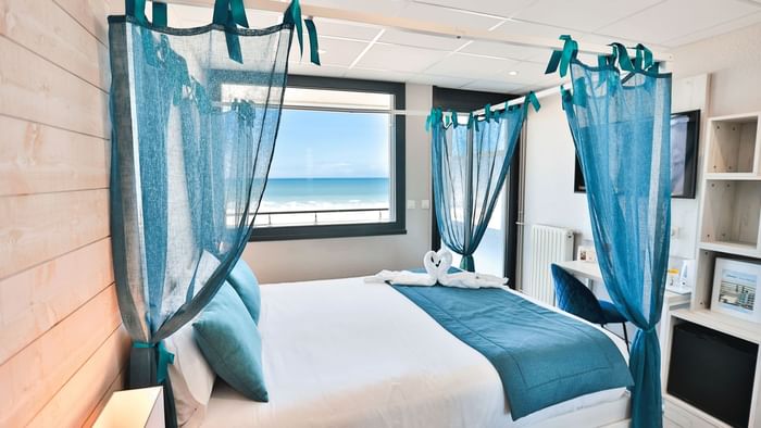 Bed with nets at Hotel Neptune at The Originals Hotels
