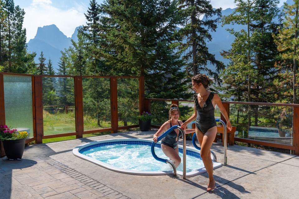 Two ladies enjoying an outdoor jacuzzi tub at Falcon Crest Lodge