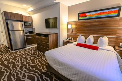 Kitchenette and a TV in Mini Queen Suite at Encore Suites Grande Prairie