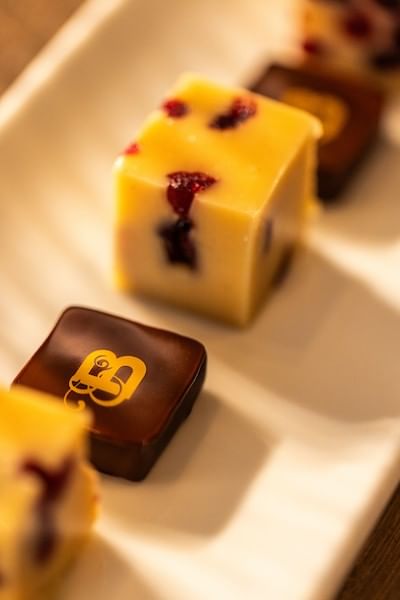 Assorted yellow and dark chocolate petit fours arranged on a white rectangular plate at The Bedford Hotel Belfast