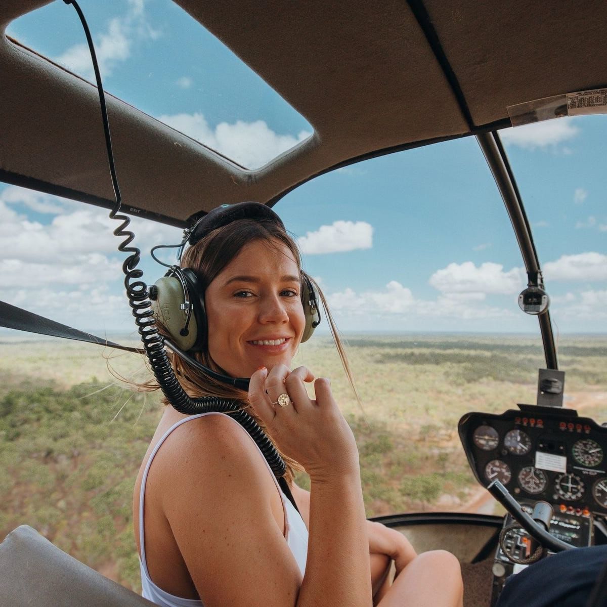A woman smiling at the camera in the helicopter near The Smith Hotel Darwin