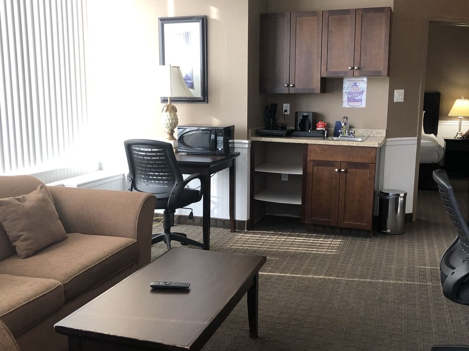 Living space with a sofa, microwave, coffee maker in Executive Suite One King at Nomad Fort McMurray