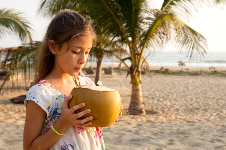 Girl drinking a king coconut near Marea Beachfront Villas