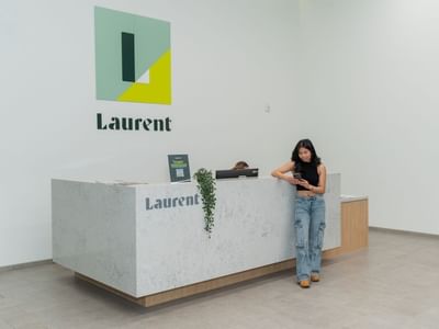 Resident standing at the front desk inside Laurent.
