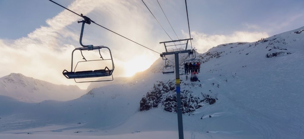 Ski lift ascending snowy slopes at Whistler Blackcomb during winter.