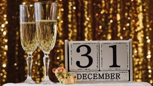 Close-up of two champagne glasses & December 31 layout on a table at Cove Pocono Resorts