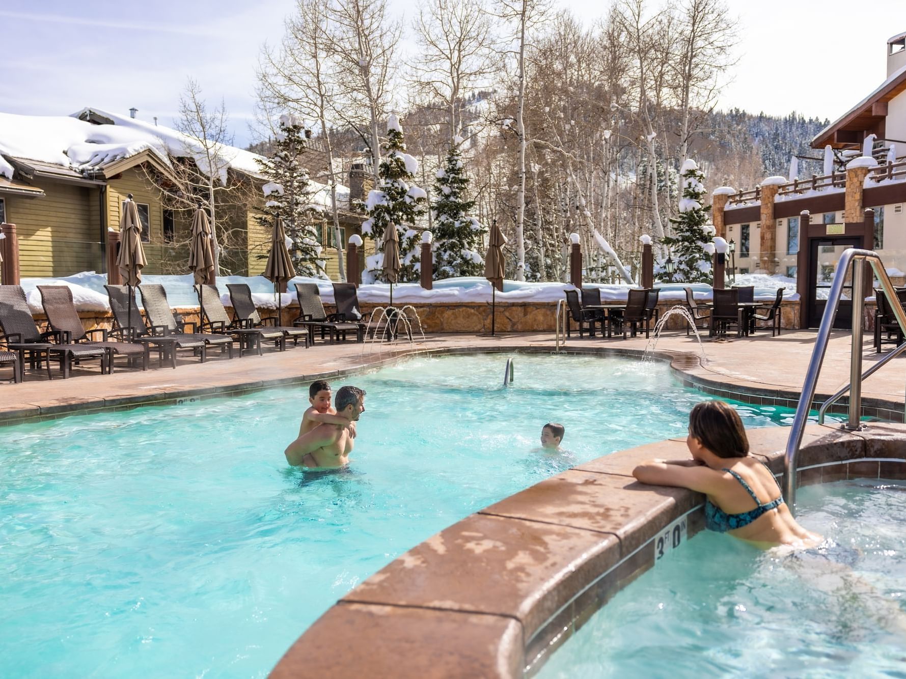 Family playing the pool in the winter time