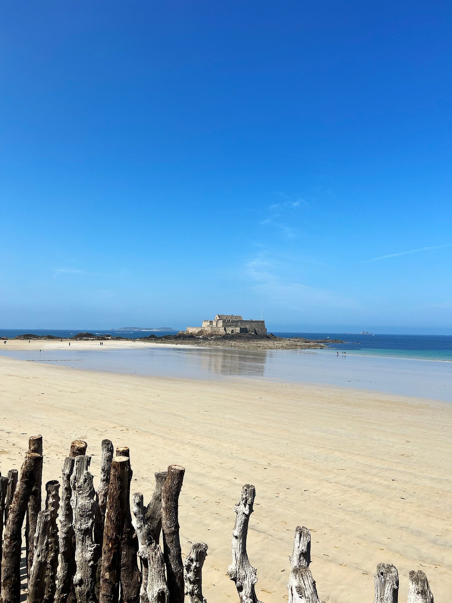 Plage de sable sereine avec un château au loin près de l'Oceania Saint-Malo
