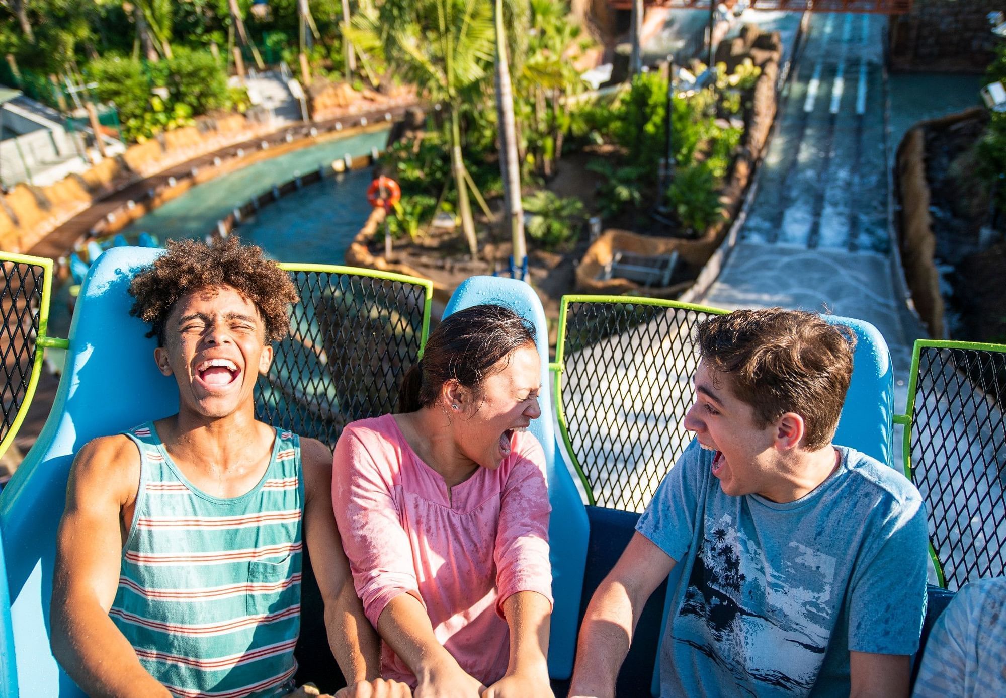 Teens laugh as they go up a hill on Infinity Falls, a water ride at SeaWorld Orlando.