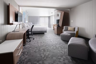 room with large bed, accent chairs and work desk