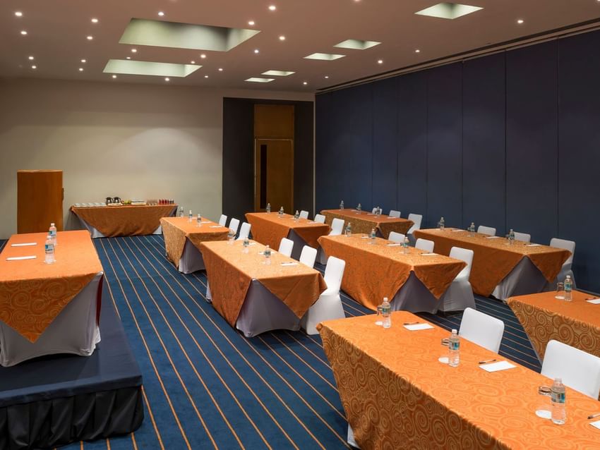 Salón Yokohama con mesas y sillas listas para reuniones en Real Inn Nuevo Laredo.