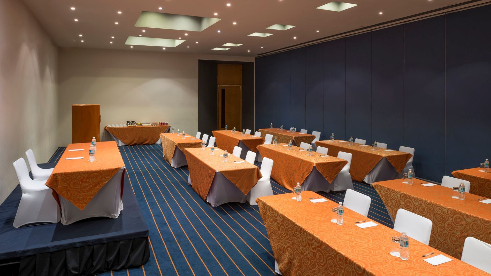 Salón Yokohama con mesas y sillas listas para reuniones en Real Inn Nuevo Laredo.