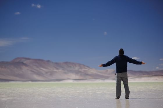 man front of Lagunas Altiplanicas near NOI Casa Atacama Hotel