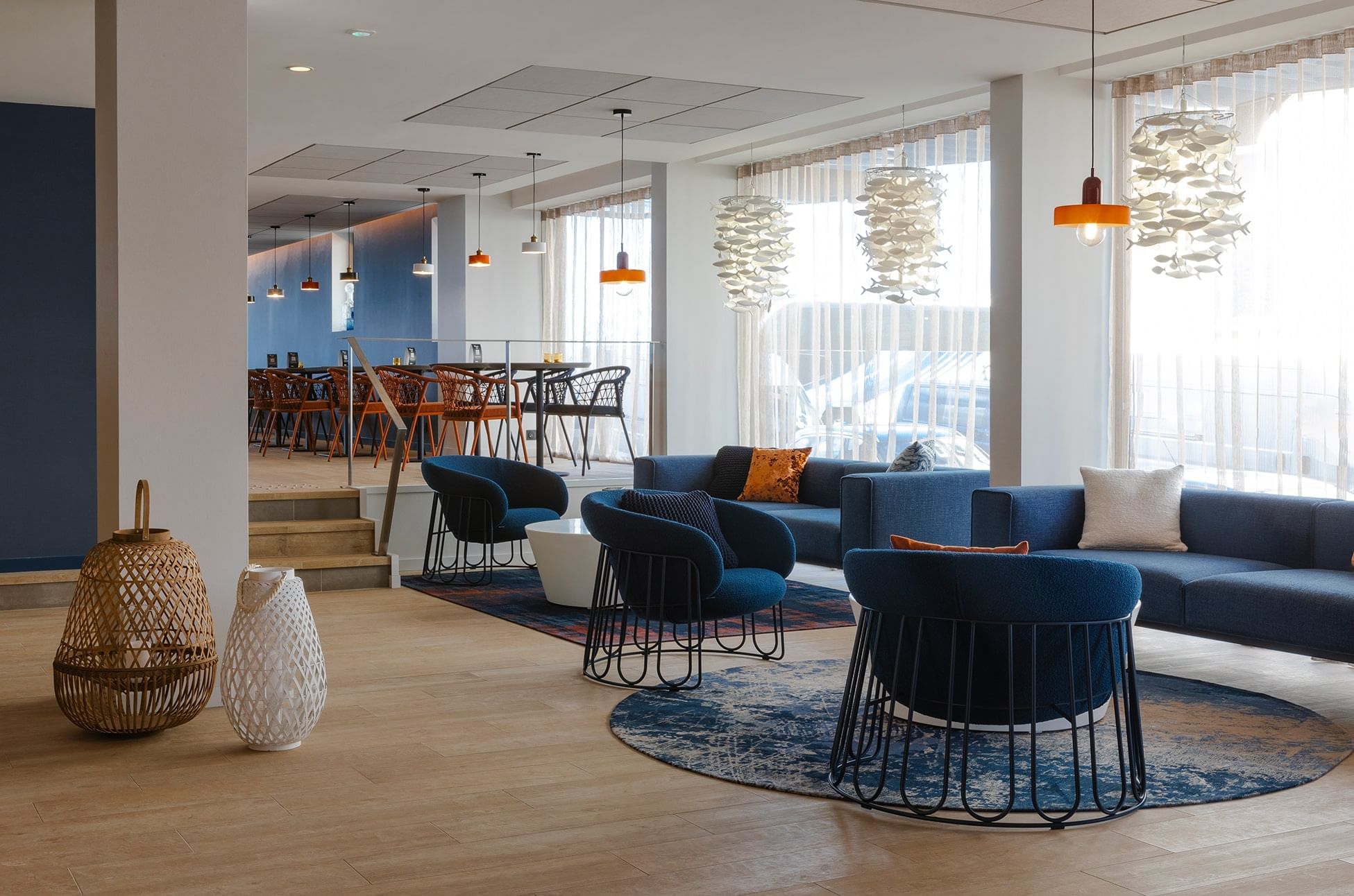 Aménagement de table à manger près d'un canapé bleu dans un restaurant à Oceania Saint-Malo