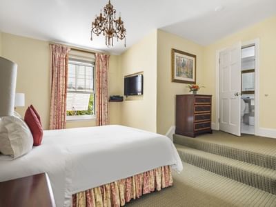 large bed in hotel suite with yellow walls