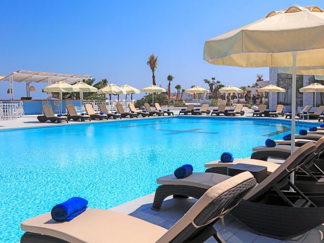 Pool area with pool chairs at Design Plus Seya Beach Hotel