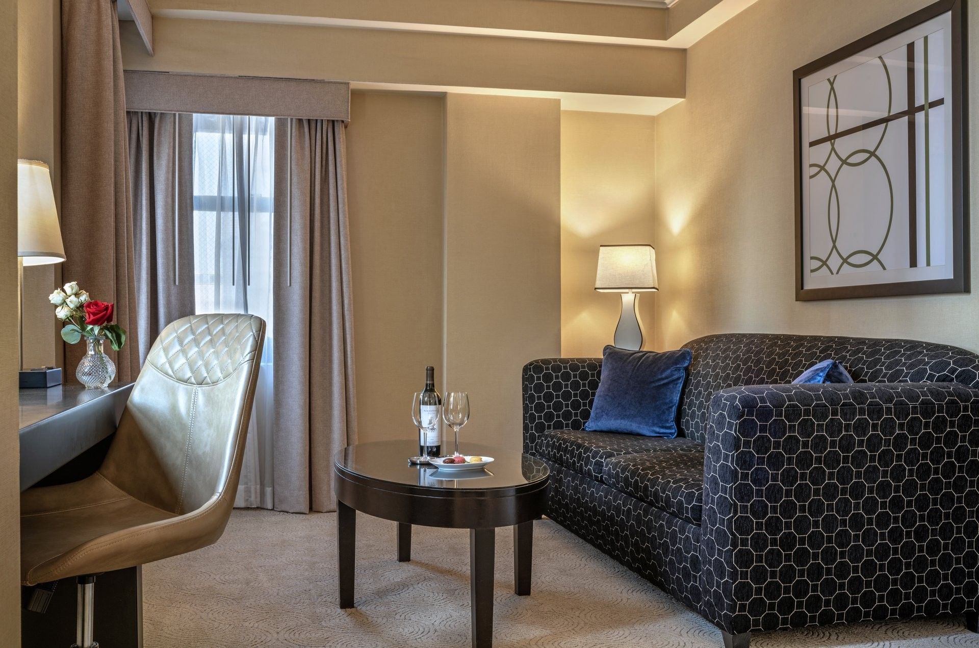 Patterned sofa with coffee table and work desk near window in Executive King at Warwick Allerton Chicago