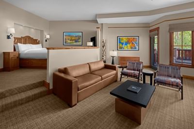 Lounge with plush seating by the window and bed in Deluxe Executive Suite at Hotel Park City Autograph Collection 