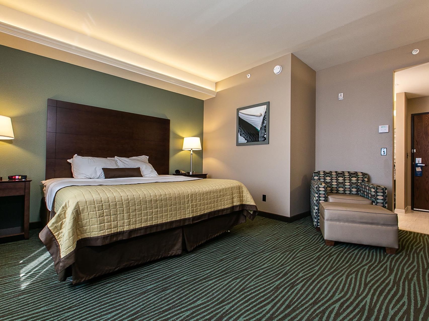 Cozy bed with chair and carpeted floor in King Handicap Resort View at Off Shore Resort
