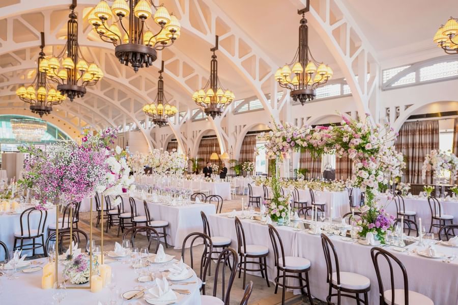 Interior of wedding hall with flower decorations and tables arranged at The Fullerton Bay Singapore