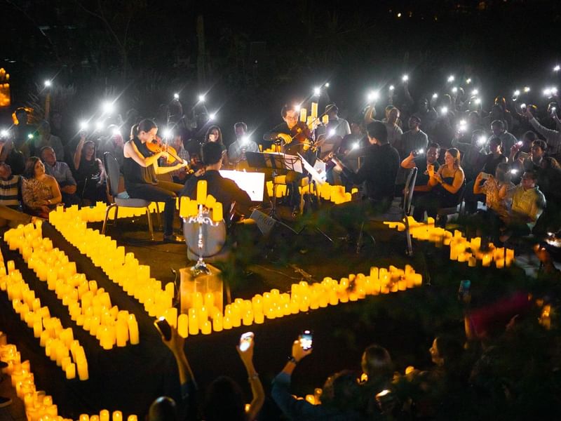 Outdoor night concert with musicians playing among candlelit paths at Live Aqua San Miguel de Allende