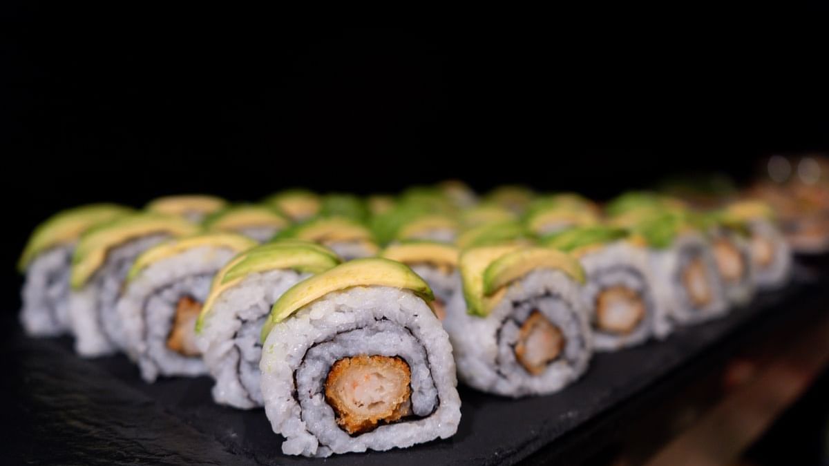 Close-up o f a row of sushi rolls topped with avocado slices at Warwick Paris Champs Elysées