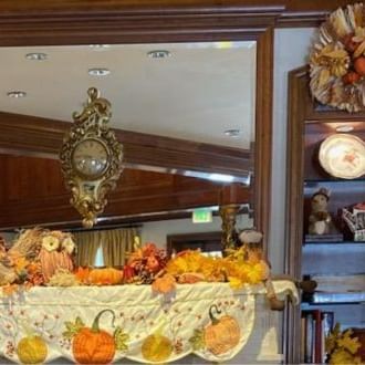 Festive autumn mantel adorned with pumpkins, colorful leaves, a decorative mirror, and a seasonal wreath at The Rose Hotel