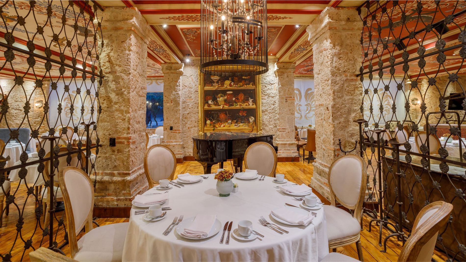 Tierra Mia restaurant with stone pillars, ornate wrought iron, and a grand piano at Quinta Real Guadalajara