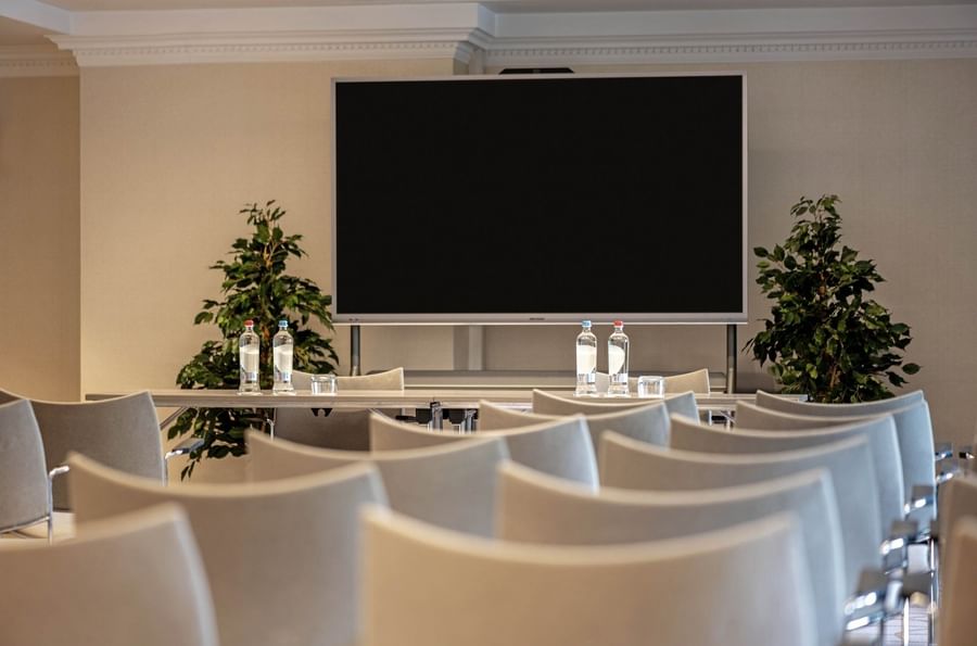 Barsey III room with theater seating facing a large screenat Hotel Barsey by Warwick