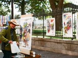 A street artist & paintings display near La Galerie Hotel