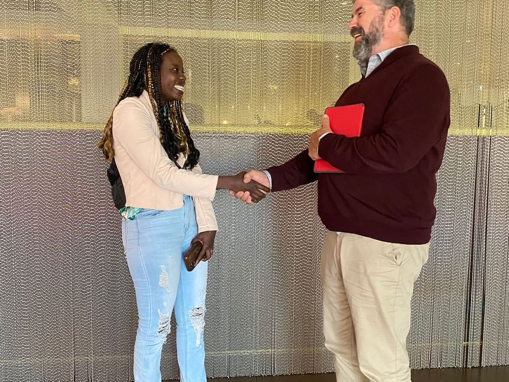 A man and a woman in jeans shake hands at Sofitel Brisbane Central