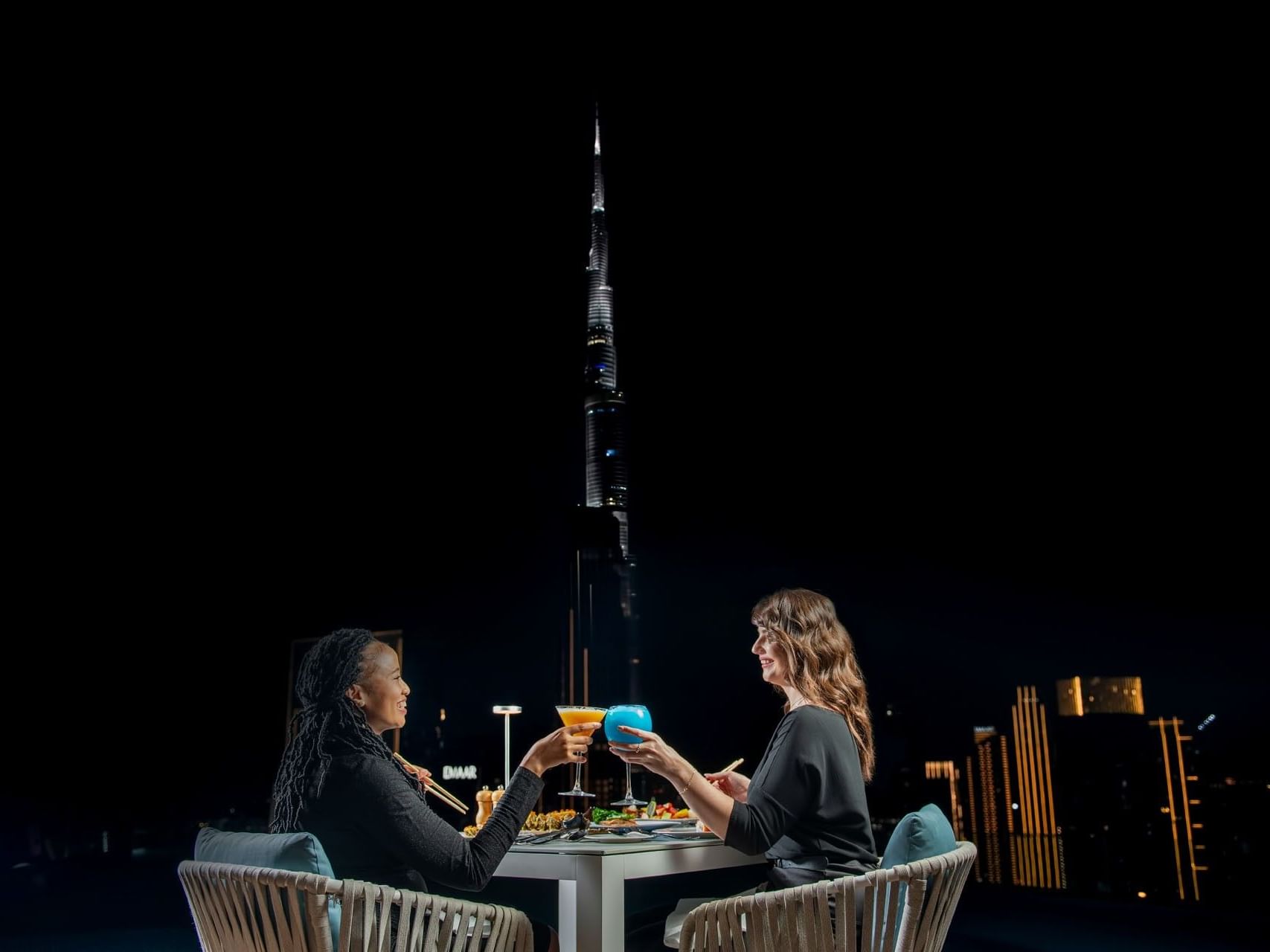 Two women having cocktails during the After Dark Friday Brunch near Burj Khalifa at Terrace Lounge in Malibu Sky Lounge & Bar