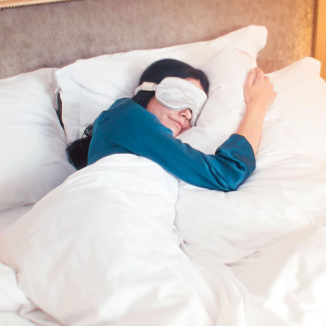 A woman peacefully sleeping in bed, wearing a white eye mask at Sofitel Brisbane Central