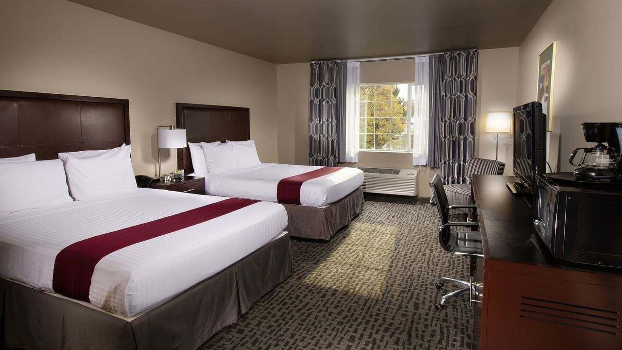 Two beds in stylish hotel room with window