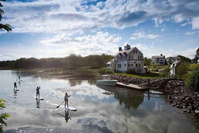 Paddleboarders on water in front of hotel
