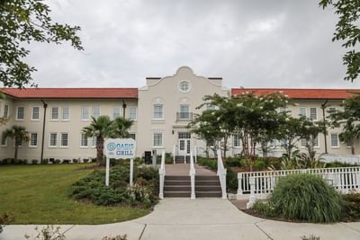 Grand facade of the historical building entrance with an Oasis Grill sign, inviting guests into the Centennial Plaza Resort