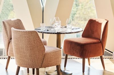 gepolsterte Stühle und Rundtisch im Restaurant Chez Bernard, Hotel MOTTO Wien