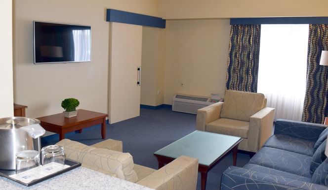 The living area with a TV & lounges in room at UMass Lowell Inn