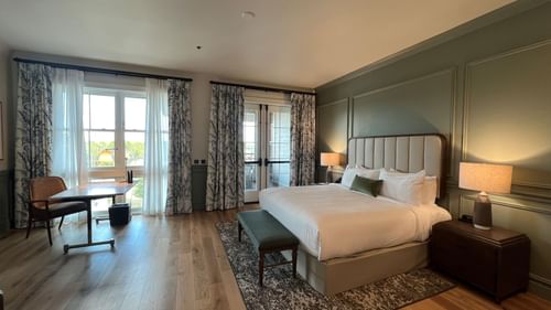 Work desk & bed by the window in King Room With Balcony at Camp Creek Inn