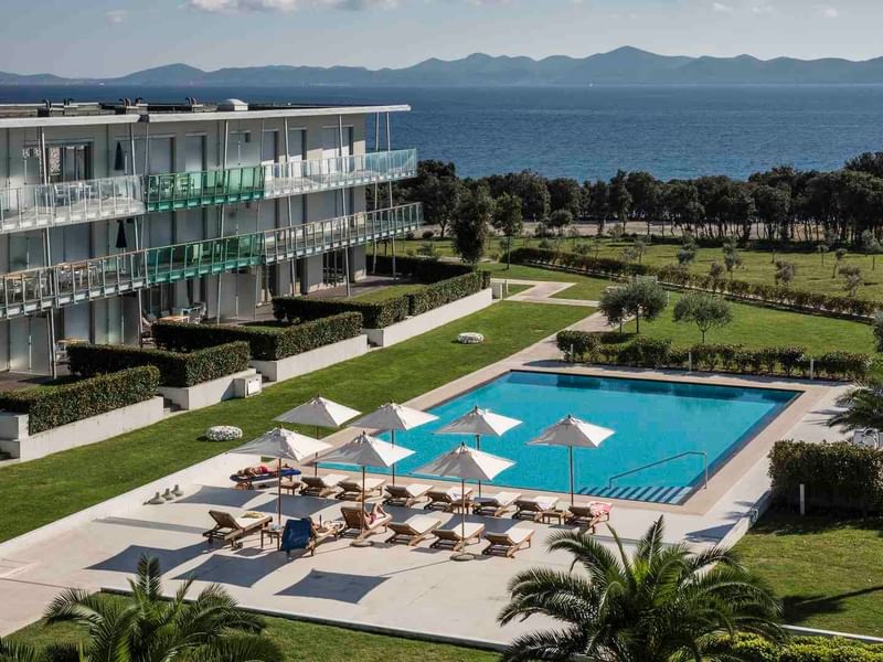 Aerial view of an outdoor pool & sunbeds, Falkensteiner Hotels