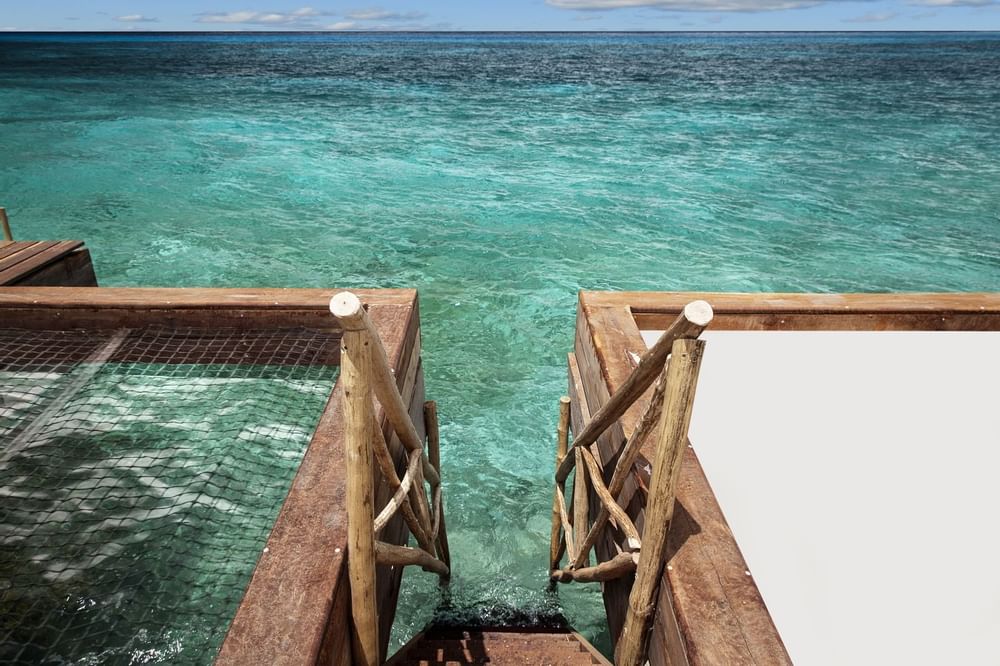 Stairway to the sea by a net lounge at Curamoria Collection