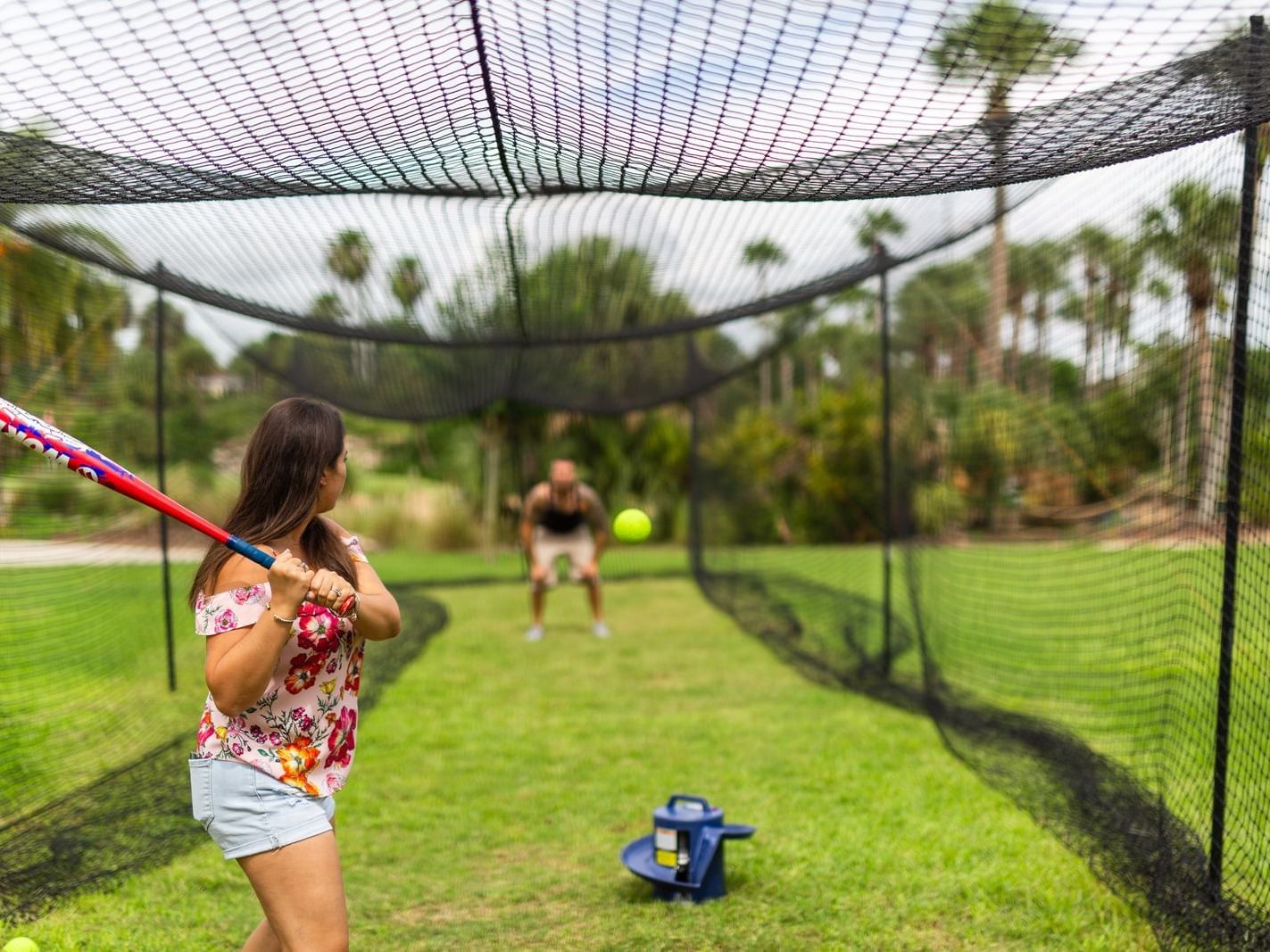 Two people at the Batting Cage in Mystic Dunes Resort