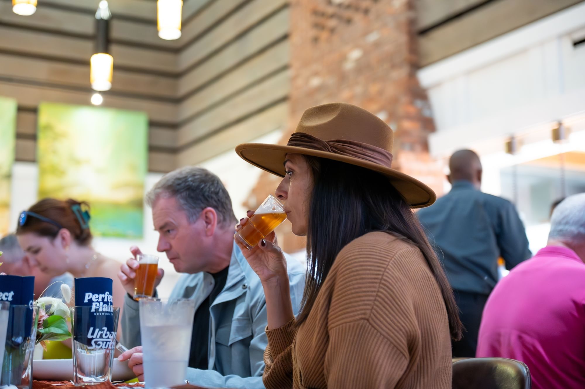 A couple tasting a beer while sitting down to dinner at a beer pairings event