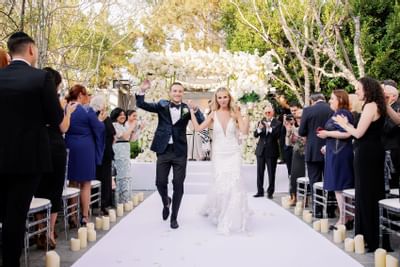 Going away of newlyweds in a ballroom with flower décor at Luxe Sunset Boulevard Hotel