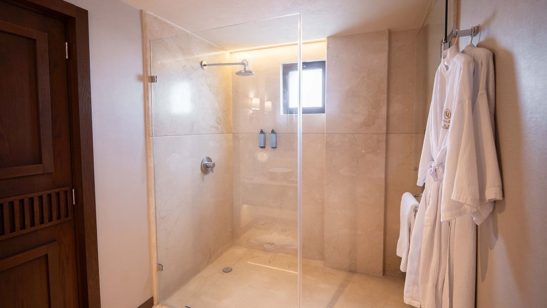 Ducha de cristal con toallas y ventana en Suite Gobernador King de Quinta Real Puebla en Heroica Puebla de Zaragoza.