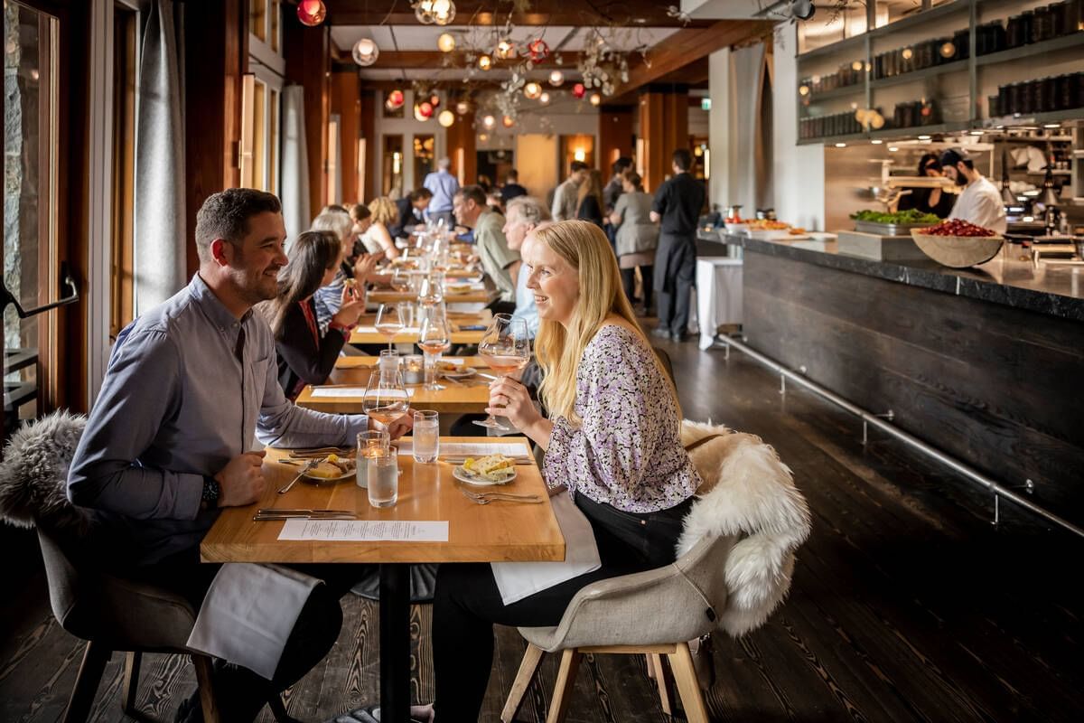 People dining in an illuminated restaurant at Blackcomb Springs Suites