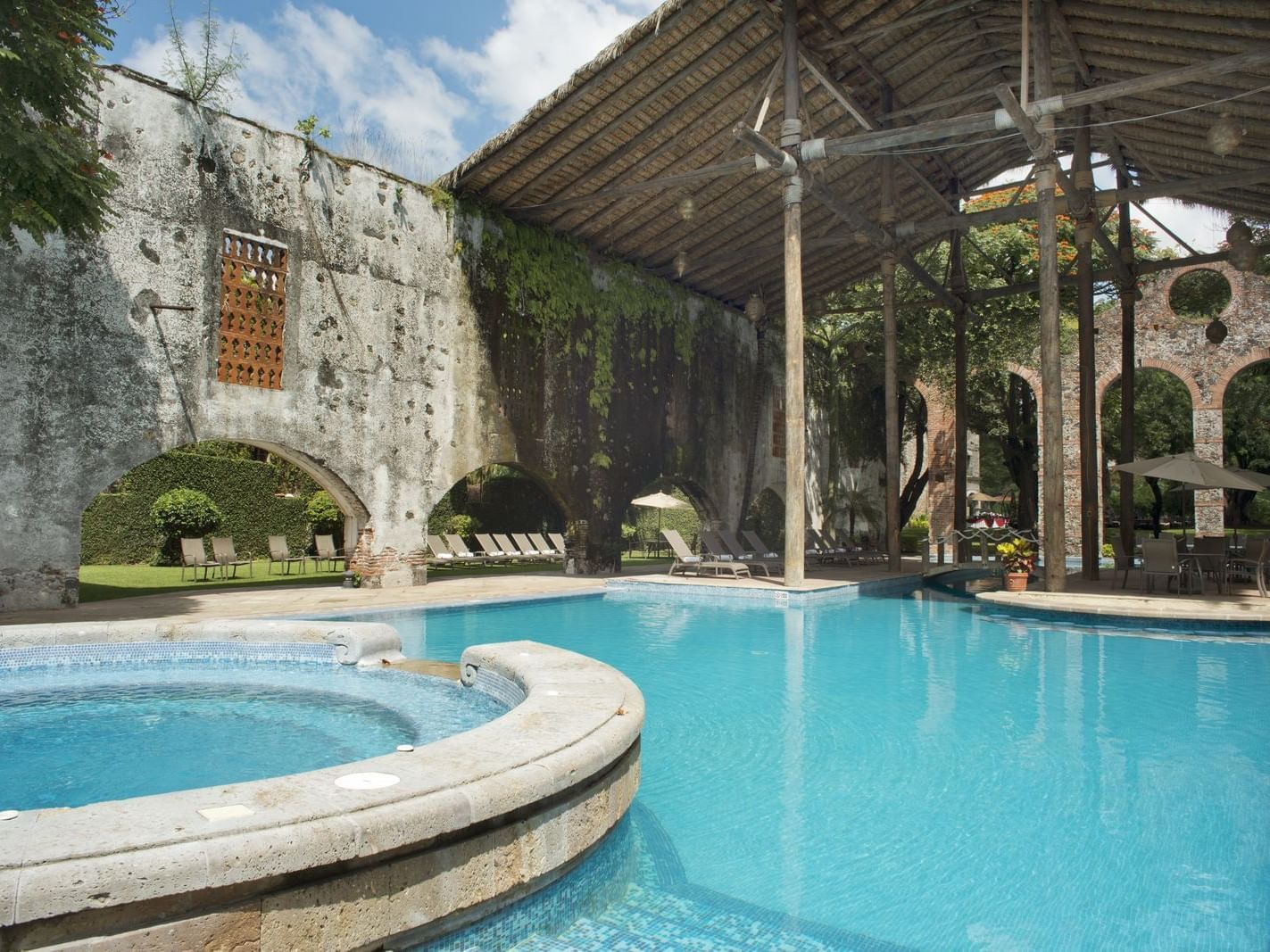 Outdoor pool area next to a Pool Bar at La Colección Resorts